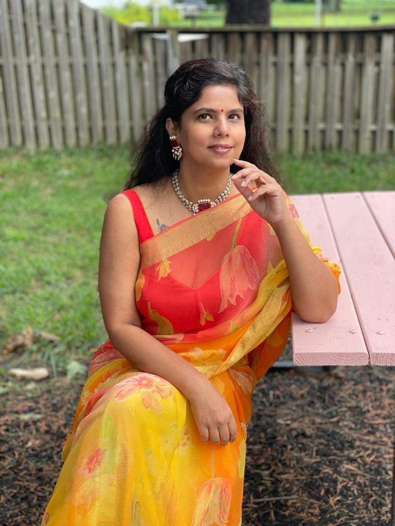 Dr. Sahila in an orange sari outdoors