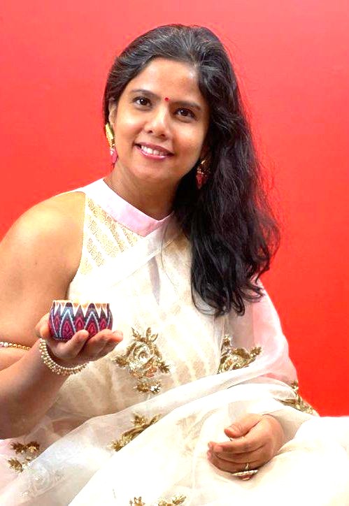 Dr. Sahila in festive traditional attire holding a diya